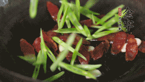 先后下香腸片、四季豆絲均勻翻炒，加適量清水燜煮一下。