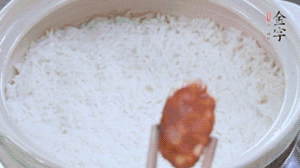 煮開后轉(zhuǎn)小火，當(dāng)米飯出現(xiàn)小孔時(shí)，鋪上金字麻辣香腸。