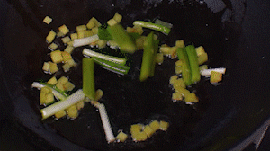 鍋中熱油，依次下姜粒、蔥段、蘆筍炒香。