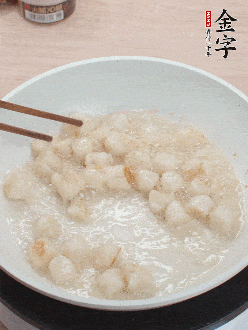 油溫4成熱，鮮貝蘸干淀粉下鍋煎，一面微黃后翻面。