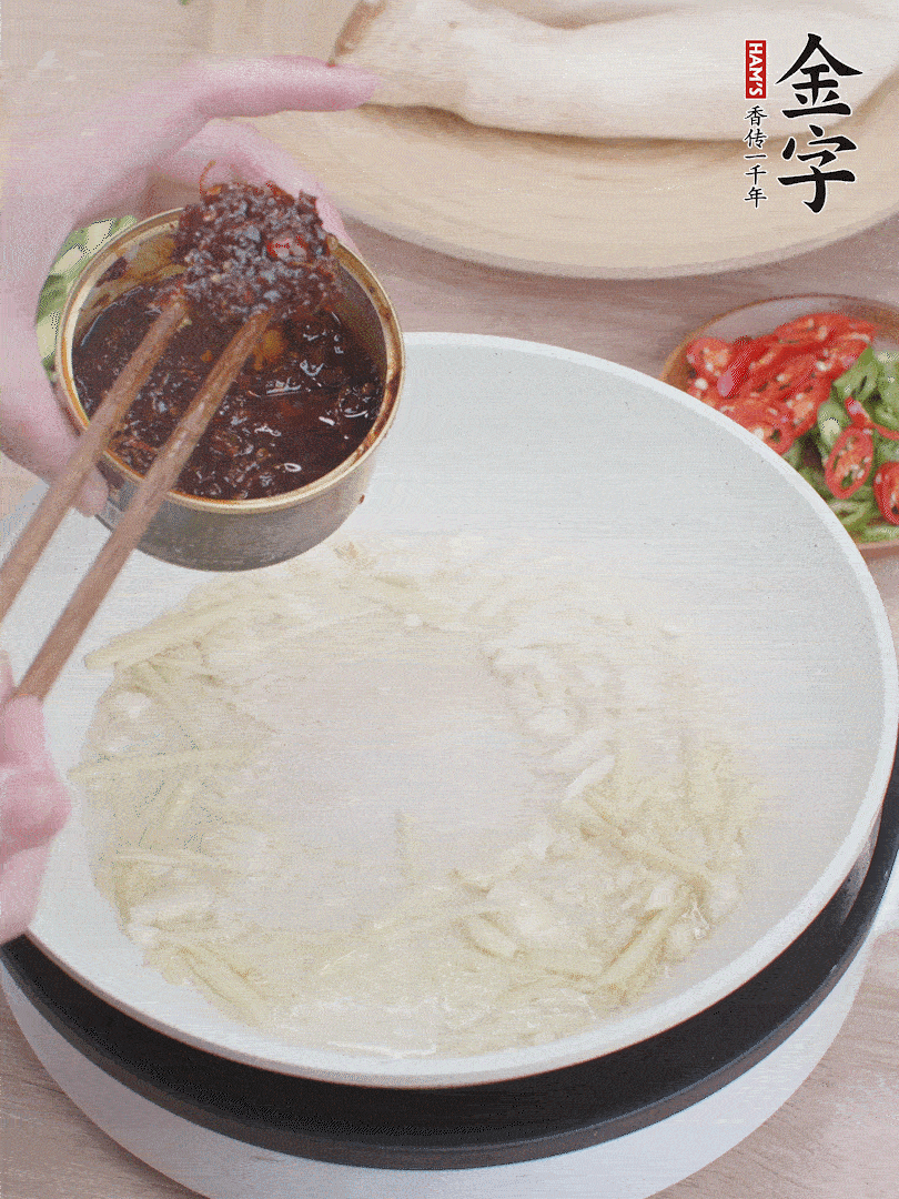 起鍋熱油，姜蒜、金字火腿干貝醬煸香。