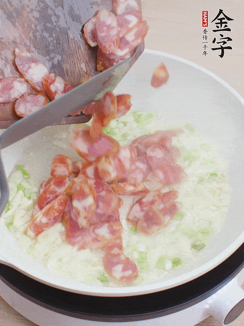 油5成熱，蒜末、蔥白爆香，下香腸炒出香味。