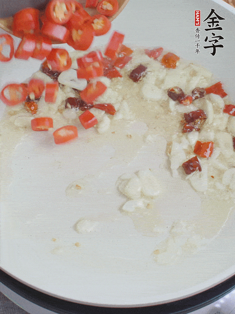 油6成熱，下蒜末、干紅辣椒煸炒，出香味后再放美人椒、香腸。