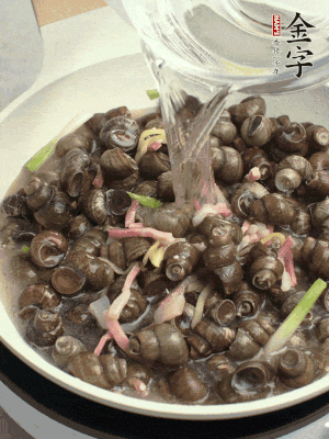 倒處理干凈的螺螄翻炒，加3勺料酒。加清水蓋過螺螄，中火蓋蓋煮5分鐘。