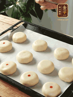 收口向下放在案板上，輕輕將月餅坯按扁，用筷子點(diǎn)紅點(diǎn)做裝飾